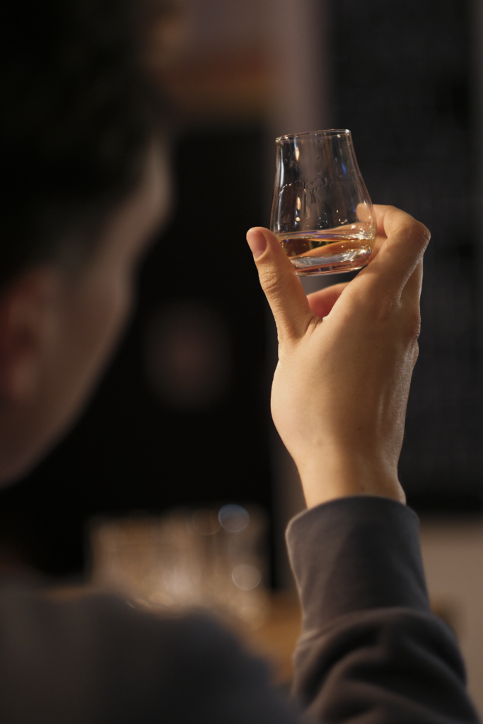 Teilnehmer betrachtet konzentriert Whiskey während professionellem Tasting-Event