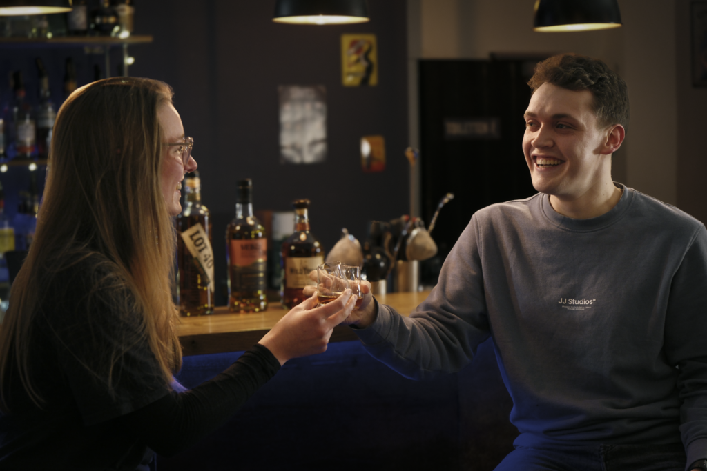 Fröhliche Teilnehmer im Gespräch während Whiskey-Tasting im Lemondrive Bar